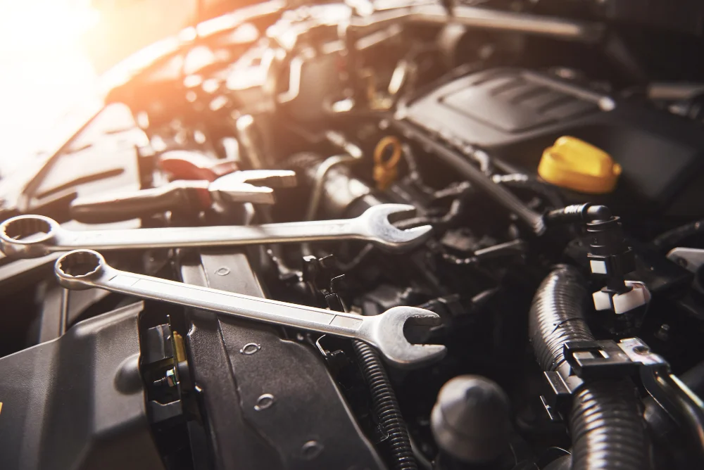 Mechanic tools next to a car engine